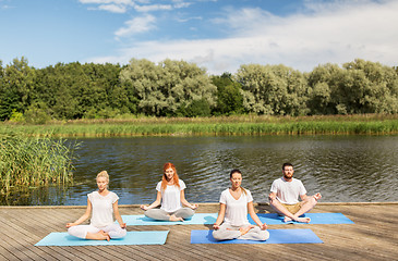 Image showing people meditating in yoga lotus pose outdoors