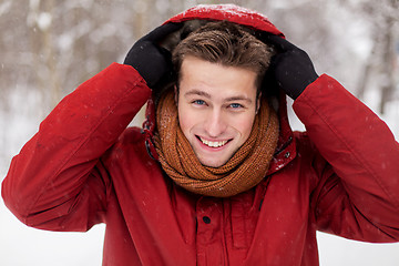 Image showing happy man in winter jacket with hood outdoors