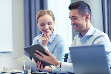 Image showing smiling business people with tablet pc in office