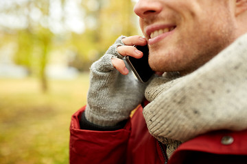 Image showing close up of man with smartphone calling in autumn