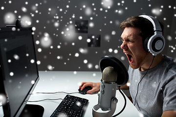 Image showing man in headset playing computer video game at home