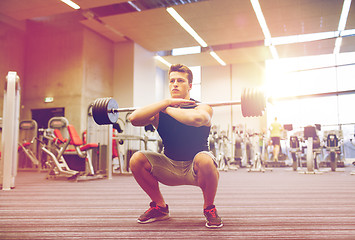 Image showing young man flexing muscles with barbell in gym