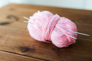 Image showing knitting needles and ball of pink yarn on wood