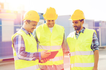 Image showing smiling builders in hardhats with tablet pc