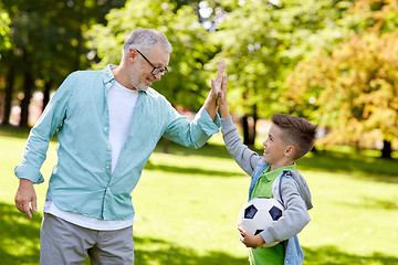 Image showing old man and boy with soccer ball making high five