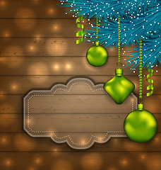 Image showing New Year label with balls and fir twigs on wooden texture with l