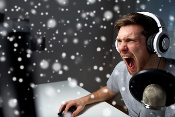 Image showing man in headset playing computer video game at home