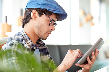 Image showing man with tablet pc sitting at cafe table