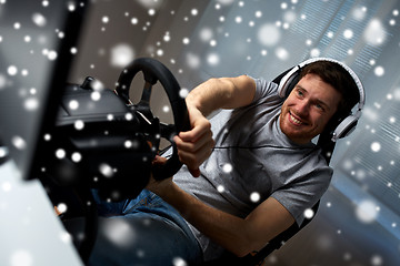 Image showing man playing car racing video game at home