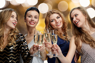 Image showing happy women clinking champagne glasses over lights