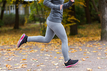 Image showing close up of young woman running in autumn park