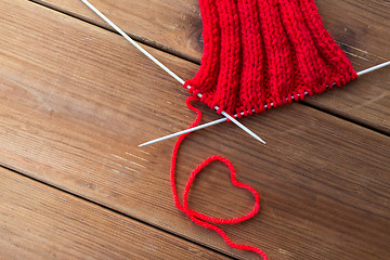 Image showing knitting needles and thread in heart shape on wood