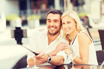 Image showing happy couple taking selfie with smartphone at cafe