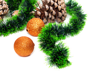 Image showing Green Christmas tinsel, Christmas-tree balls and pine cones