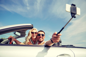 Image showing happy couple in car taking selfie with smartphone