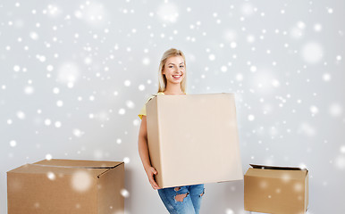 Image showing smiling young woman with cardboard box at home