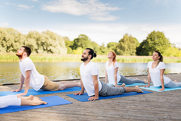 Image showing group of people making yoga exercises outdoors