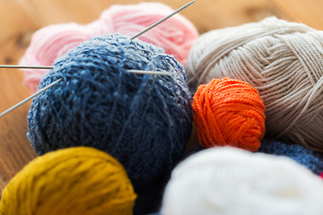 Image showing knitting needles and balls of yarn on wood