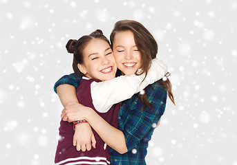 Image showing happy smiling teenage girls hugging over snow