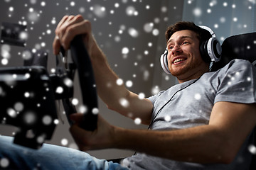 Image showing man playing car racing video game at home