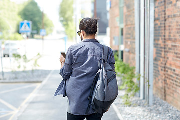 Image showing man with backpack and smartphone walking in city