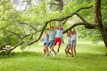 Image showing happy kids hanging on tree in summer park