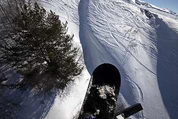 Image showing Snowboard over off-piste slope in sun winter day