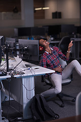 Image showing woman at her workplace in startup business office listening musi