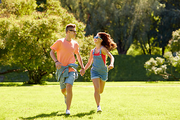 Image showing happy teenage couple running at summer park