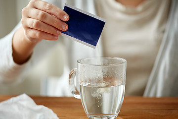 Image showing woman pouring medication into cup of water