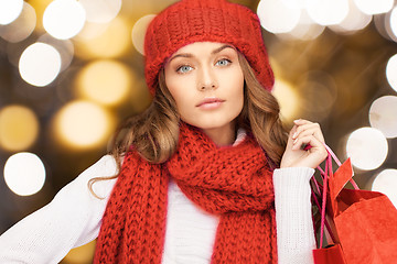 Image showing woman in red hat and scarf holding shopping bags