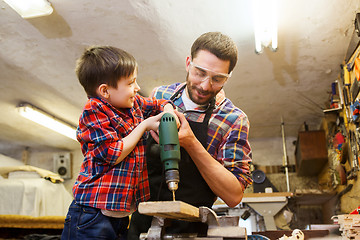 Image showing father and son with drill working at workshop