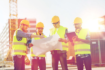 Image showing group of builders with tablet pc and blueprint