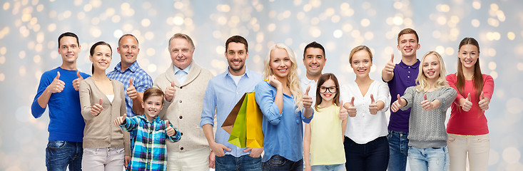 Image showing happy people with shopping bags showing thumbs up