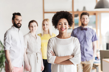 Image showing happy young woman over creative team in office