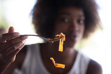 Image showing a young African American woman eating pasta