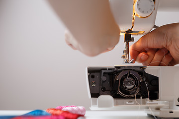 Image showing Girl prepares sewing-machine to work