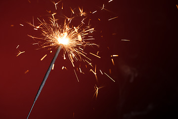 Image showing Christmas sparkler on red background