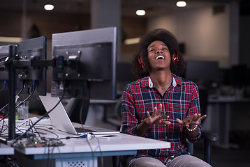 Image showing woman at her workplace in startup business office listening musi