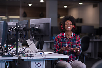 Image showing woman at her workplace in startup business office listening musi