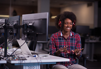 Image showing woman at her workplace in startup business office listening musi