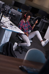 Image showing woman at her workplace in startup business office listening musi