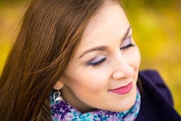 Image showing Rub a beautiful girl with closed eyes on a blurred background of autumn leaves