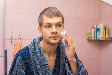 Image showing The young man begins to apply shaving foam on face