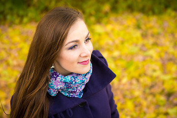 Image showing Rub a beautiful girl on the blurry background of autumn leaves