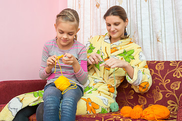 Image showing Mom and daughter seven-year-knit on the needles at home