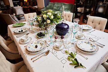 Image showing Beautifully decorated table set with flowers, candles, plates and serviettes for wedding or another event in the restaurant.