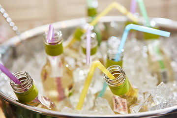 Image showing bottles with tasty drink in ice. Shallow dof