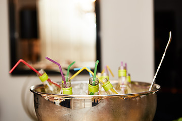 Image showing bottles with tasty drink in ice. Shallow dof