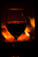 Image showing Wineglass by a cozy fire